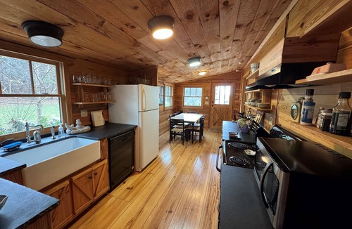 Ellijay Cabin | These charming cabins blend modern design with rustic beauty, offering a peaceful retreat where the main cabin sits one step from a stream, perfect for dining by the water, with stunning views of the surrounding landscape.
